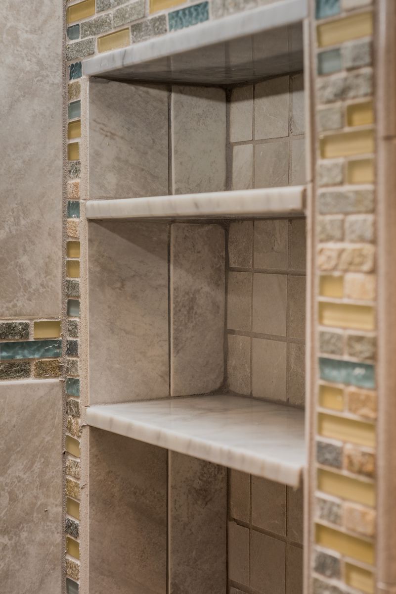 Tiled shower niche with a glass accent band